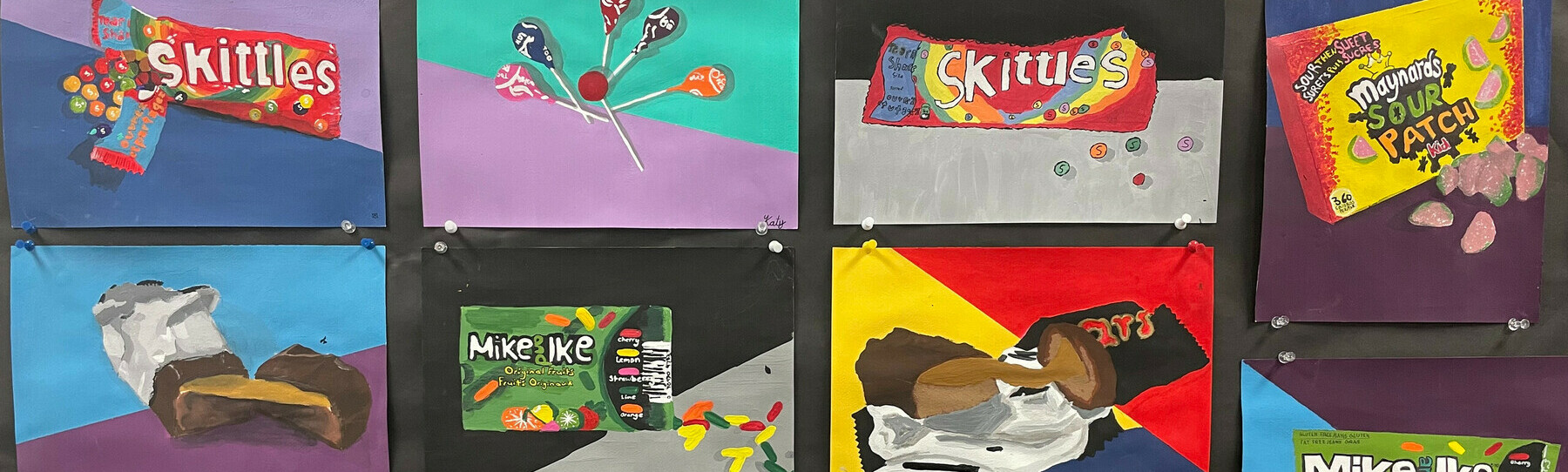 Student created art pieces in pop art style on display at NSS. The subject of the art pieces are candy and chocolate bar wrappers. 